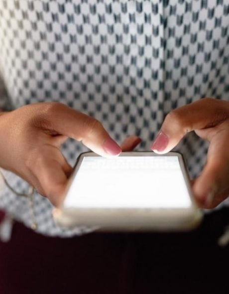 A manager is getting in touch to book a coaching session using her mobile phone.